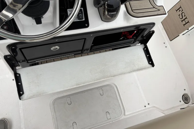 Slide: The Image of 2023 Yamaha Boats 222 FSH Sport helm with steering wheel and control panel. - 11