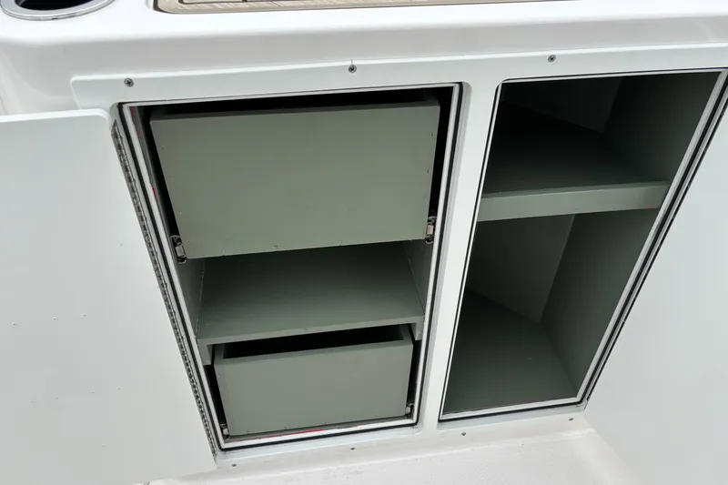 Slide: The Image of 2023 Yamaha Boats 222 FSH Sport storage compartments with open drawers and shelves. - 3