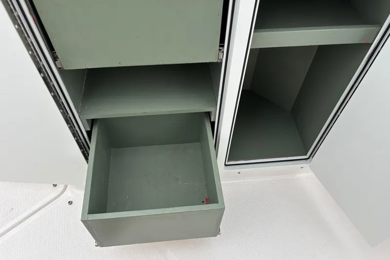 Slide: The Image of 2023 Yamaha Boats 222 FSH Sport storage compartments with open drawers and shelves. - 5