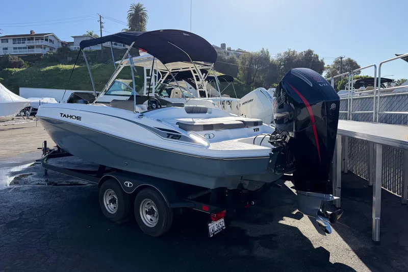 Slide: The Image of 2024 Tahoe T21 boat on trailer with outboard motor, parked outdoors. - 1