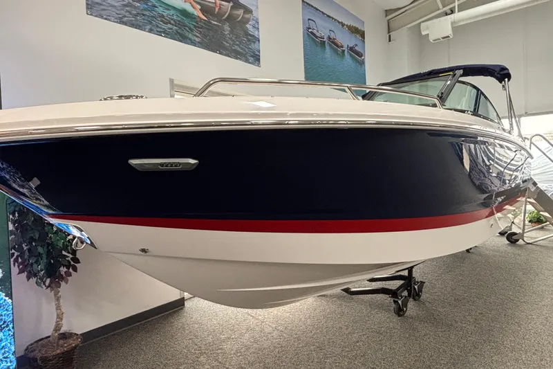 Slide: The Image of 2026 Chaparral SSX 4 boat displayed indoors, featuring sleek design and navy blue exterior. - 26