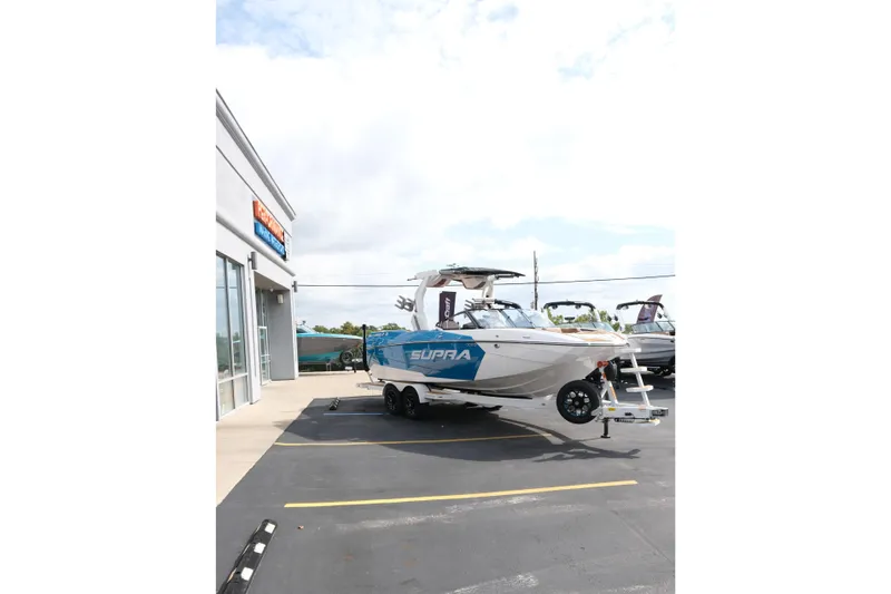 Slide: The Image of 2026 Supra SL boat parked outside dealership on a sunny day. - 11