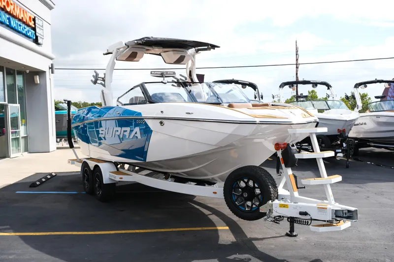 Slide: The Image of 2026 Supra SL boat on trailer at dealership, showcasing sleek design and modern features. - 12