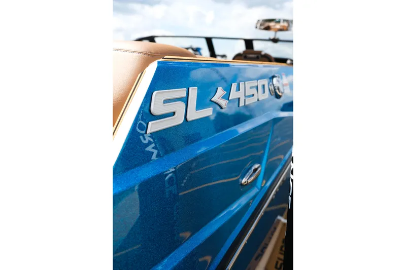 Slide: The Image of 2026 Supra SL boat, blue exterior, SL 450 emblem, close-up view. - 13