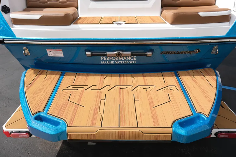 Slide: The Image of 2026 Supra SL boat with teak deck and blue accents, featuring Swell Surf technology. - 14