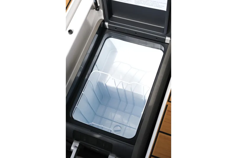 Slide: The Image of 2026 Supra SL boat cooler compartment, open lid, spacious interior. - 26