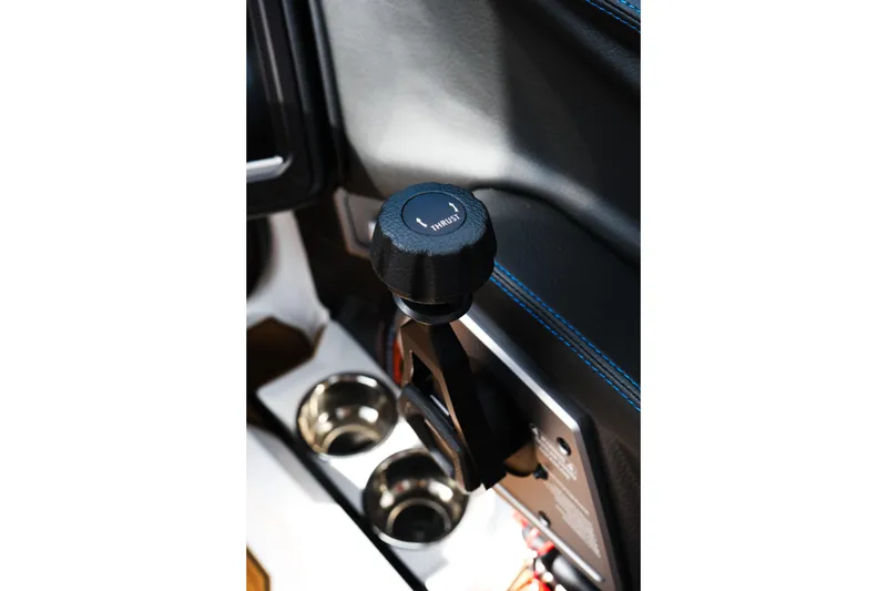 Slide: The Image of 2026 Supra SL interior with gear shift and cup holders, featuring blue stitching. - 32