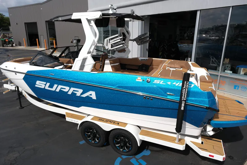 Slide: The Image of 2026 Supra SL boat in vibrant blue, parked on a trailer outside a showroom. - 4