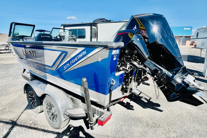 Slide: The Image of 2026 Lund 2075 Fisherman boat with powerful outboard motor, parked on a trailer. - 3