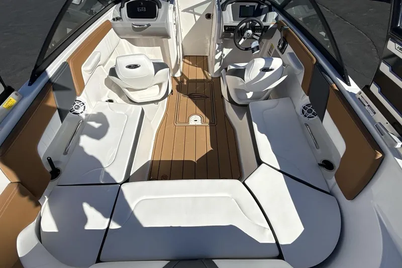 Slide: The Image of 2025 Chaparral 23 SSi boat interior with white seating and wood accents. - 10