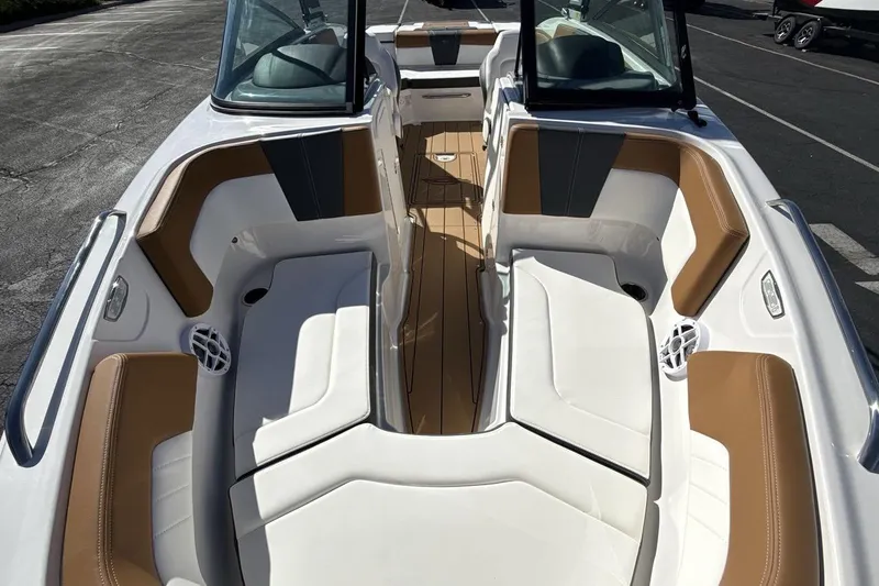 Slide: The Image of 2025 Chaparral 23 SSi boat interior with white and tan seating, open bow design. - 12