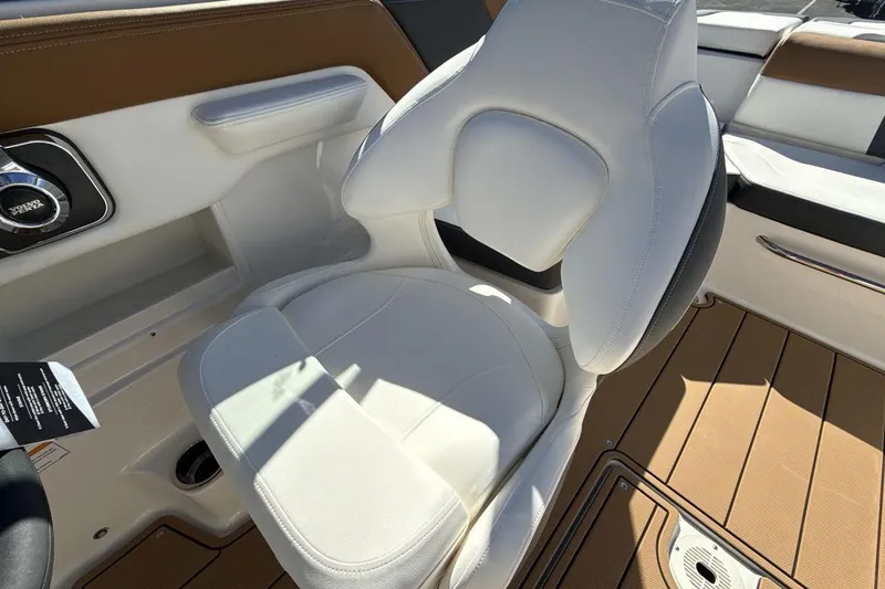 Slide: The Image of 2025 Chaparral 23 SSi boat interior with white cushioned seat and brown flooring. - 13