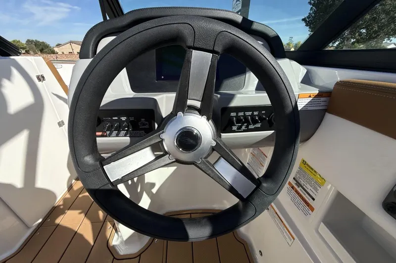 Slide: The Image of Steering wheel of 2025 Chaparral 23 SSi boat, featuring modern dashboard controls. - 14
