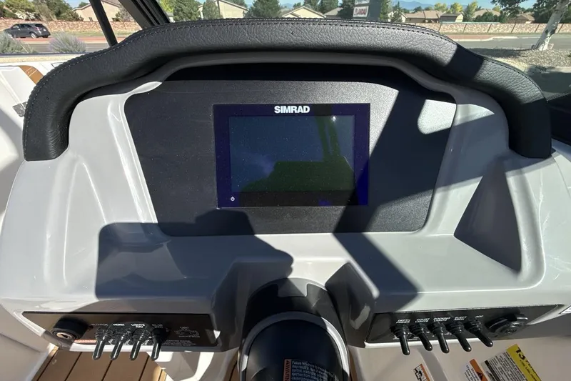 Slide: The Image of 2025 Chaparral 23 SSi dashboard featuring a Simrad display and control panel. - 15