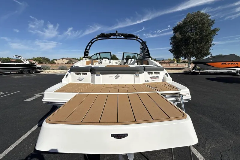 Slide: The Image of 2025 Chaparral 23 SSi boat with spacious deck, parked outdoors under clear sky. - 4