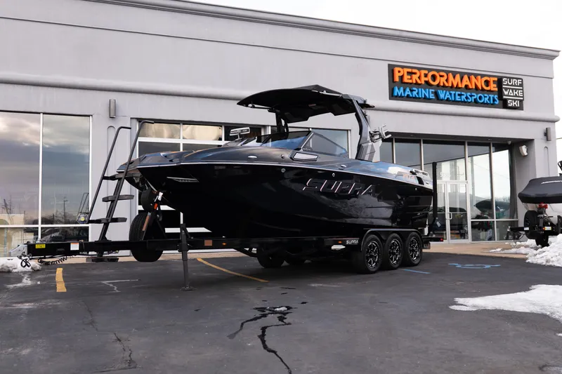 The Image of 2024 Supra SE boat on trailer at Performance Marine Watersports dealership. - 1