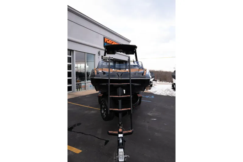 Slide: The Image of 2024 Supra SE boat on trailer outside dealership in winter setting. - 10