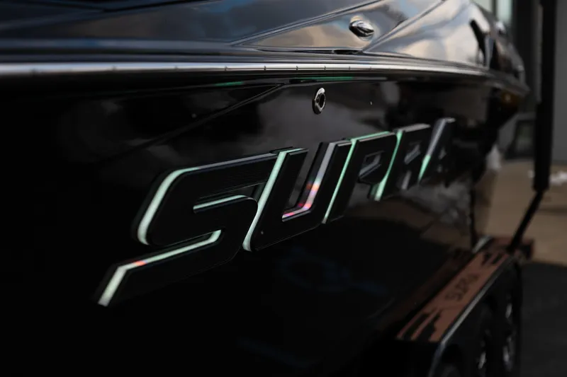 Slide: The Image of 2024 Supra SE boat with sleek black exterior and illuminated logo. - 11