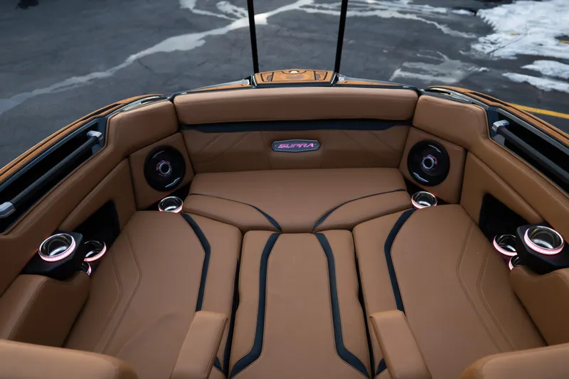 Slide: The Image of 2024 Supra SE interior with tan leather seating, cup holders, and speakers. - 15