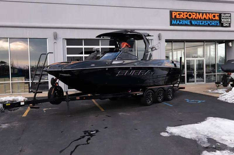 Slide: The Image of 2024 Supra SE boat on trailer at Performance Marine Watersports dealership. - 2