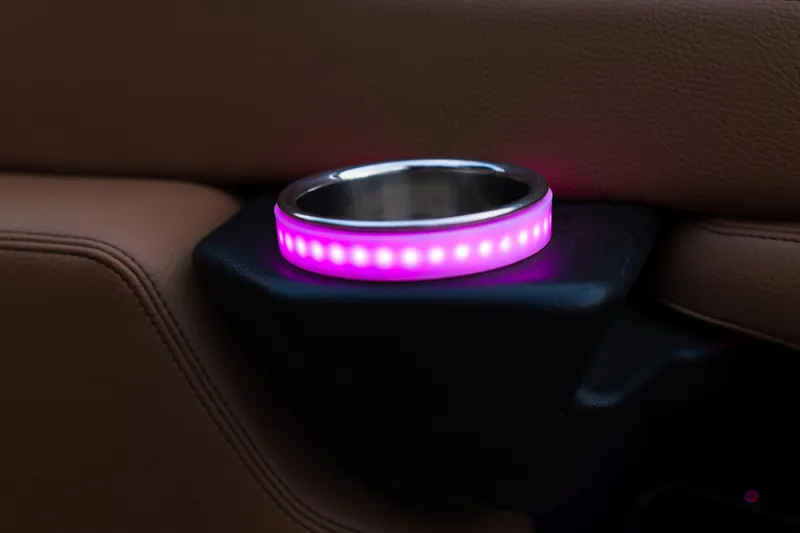 Slide: The Image of 2024 Supra SE interior with illuminated cup holder, featuring pink LED lights and brown leather upholstery. - 20