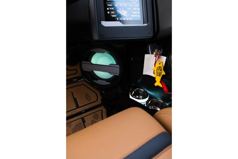 Slide: The Image of 2024 Supra SE interior with touchscreen, cup holders, and keychain detail. - 26