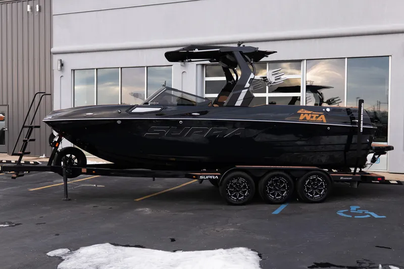 Slide: The Image of 2024 Supra SE boat on trailer, parked outside a building. - 3