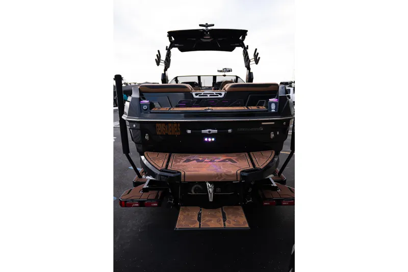 Slide: The Image of 2024 Supra SE boat rear view with custom deck design and lighting. - 6