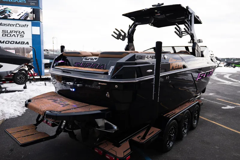 Slide: The Image of 2024 Supra SE boat with sleek design, displayed outdoors on a trailer. - 7