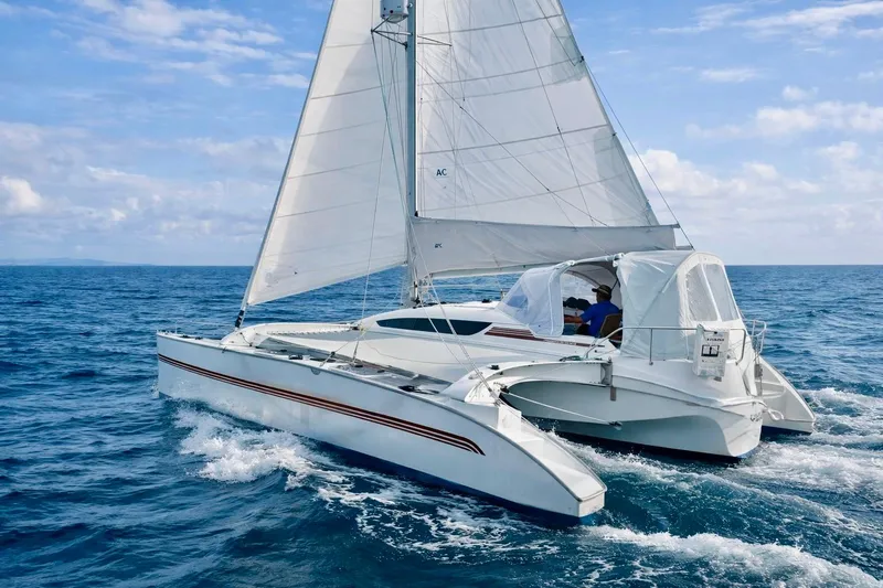 Slide: The Image of Sailing on open sea, 2016 Dragonfly 32 trimaran with white sails and blue sky. - 0