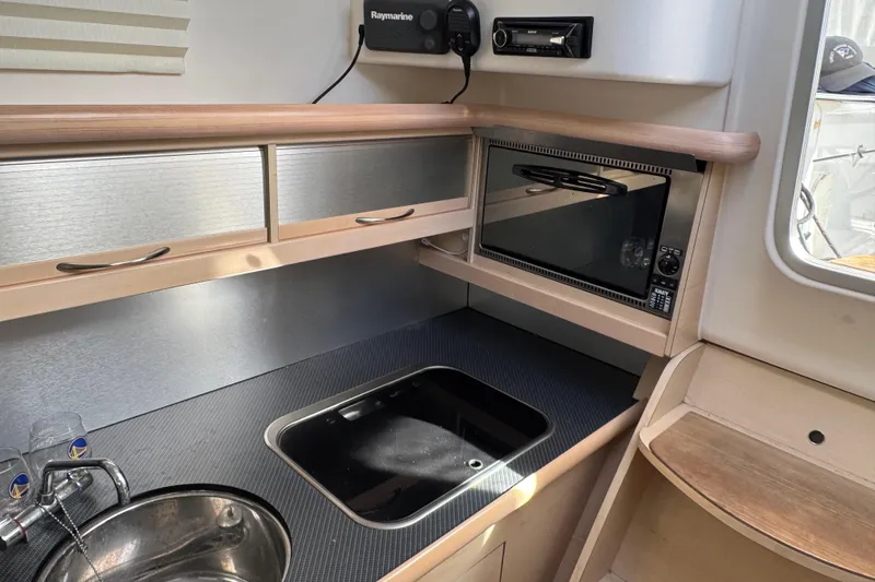 Slide: The Image of Compact kitchen area in a 2016 Dragonfly 32 sailboat, featuring a sink and microwave. - 27
