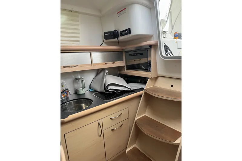 Slide: The Image of Interior of a 2016 Dragonfly 32 sailboat, featuring wooden steps and storage area. - 4