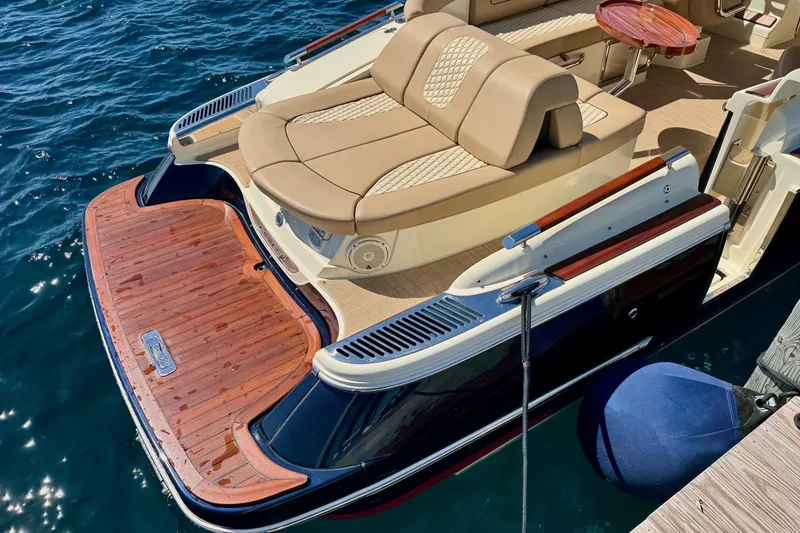 Slide: The Image of 2019 Chris-Craft Launch 28 GT boat with elegant seating and wooden deck on water. - 2