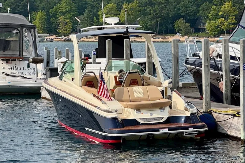 Slide: The Image of 2019 Chris-Craft Launch 28 GT docked at marina, featuring elegant design and American flag. - 8