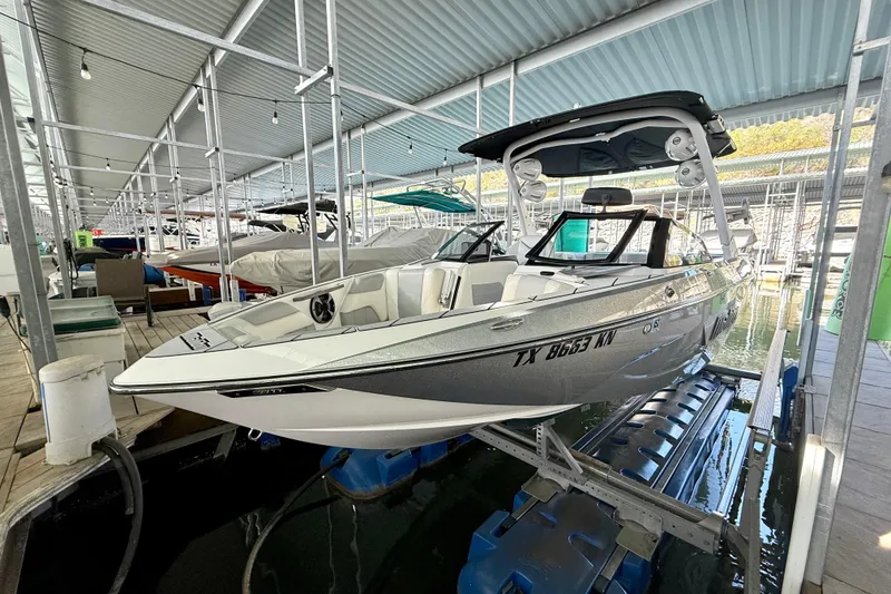 Slide: The Image of 2021 Malibu Wakesetter 25 LSV boat docked in a covered marina. - 13
