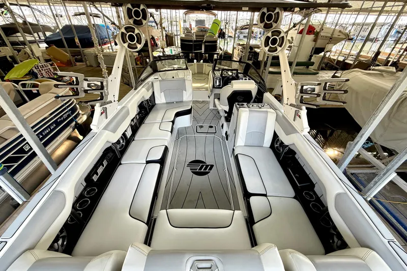 Slide: The Image of 2021 Malibu Wakesetter 25 LSV interior with spacious seating and modern design in a marina. - 16