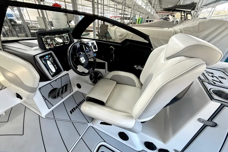 Slide: The Image of 2021 Malibu Wakesetter 25 LSV boat interior with modern dashboard and captain's seat. - 22