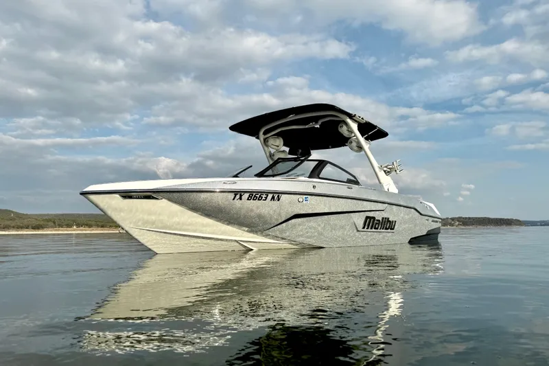 Slide: The Image of 2021 Malibu Wakesetter 25 LSV boat on calm water under cloudy sky. - 3