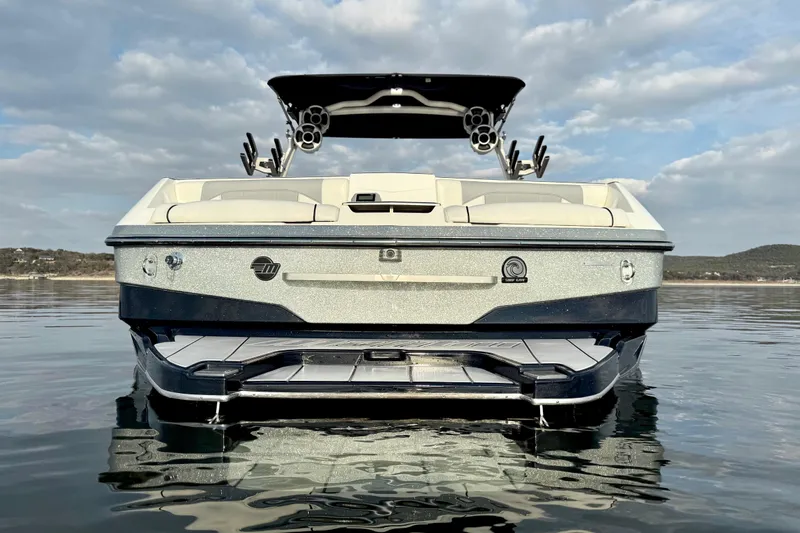 Slide: The Image of 2021 Malibu Wakesetter 25 LSV on calm water, rear view with speakers and seating. - 4