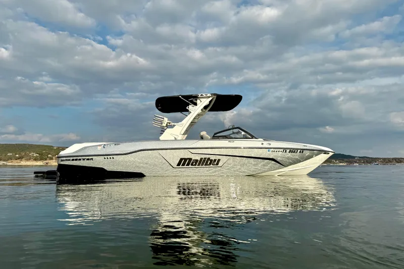 Slide: The Image of 2021 Malibu Wakesetter 25 LSV boat on calm water under cloudy sky. - 6