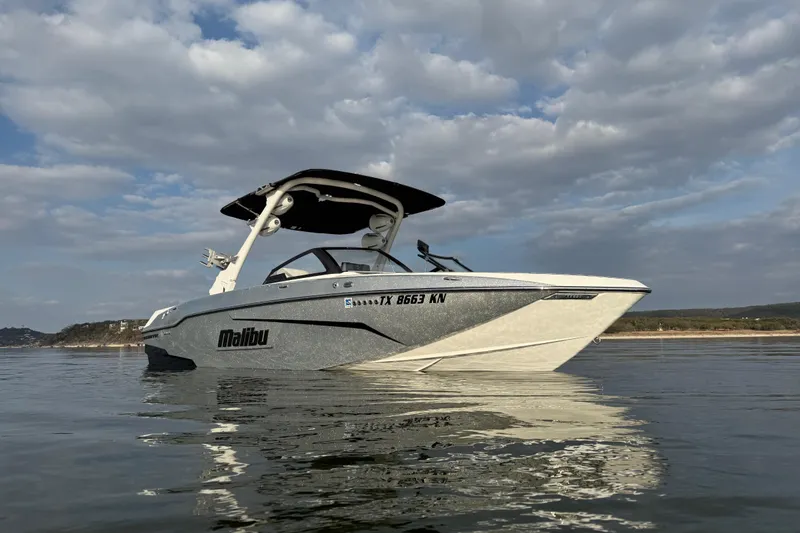 Slide: The Image of 2021 Malibu Wakesetter 25 LSV boat on calm water under cloudy sky. - 7