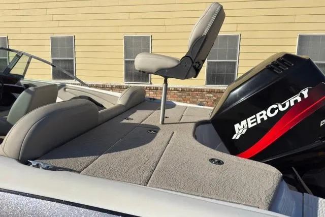 Slide: The Image of 2002 Triton SF-21 boat with Mercury engine and seating, docked near a building. - 6