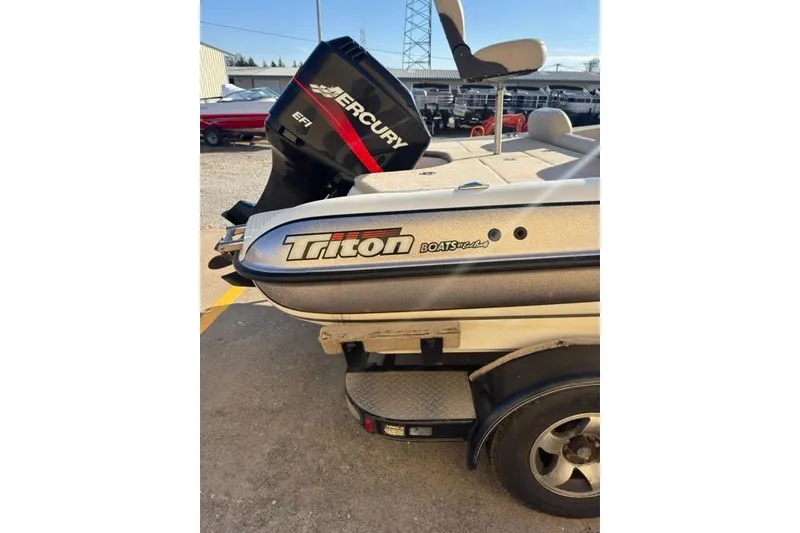 Slide: The Image of 2002 Triton SF-21 boat with Mercury EFI engine, parked on a trailer. - 8