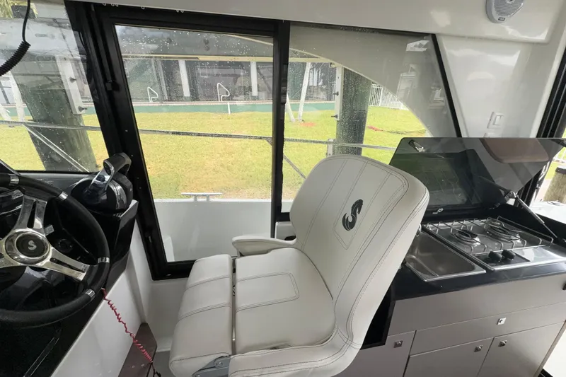 Slide: The Image of Interior of 2020 Beneteau Antares 9, featuring helm and compact kitchen area. - 10