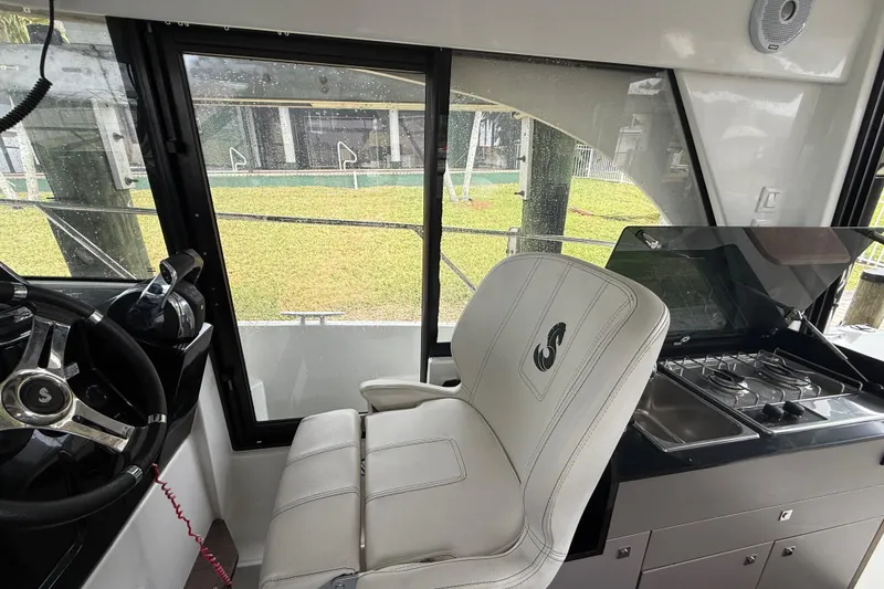 Slide: The Image of Interior of 2020 Beneteau Antares 9 boat with steering wheel and kitchenette. - 11