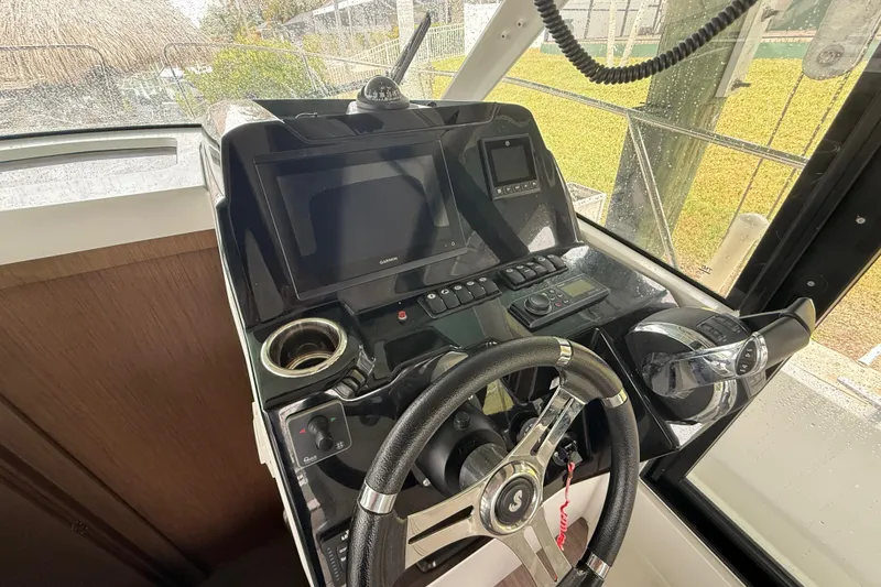 Slide: The Image of Helm of 2020 Beneteau Antares 9 with steering wheel and navigation controls. - 12
