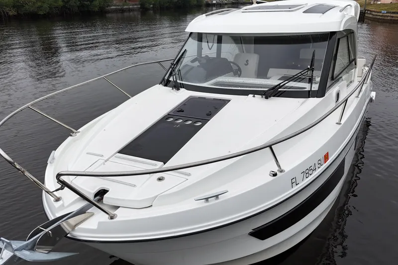 Slide: The Image of 2020 Beneteau Antares 9 boat docked on calm water, showcasing sleek design. - 2