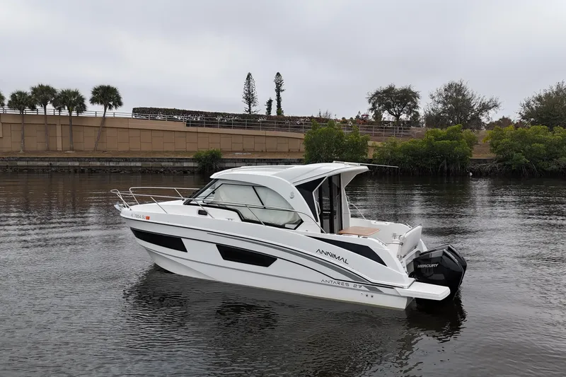 Slide: The Image of 2020 Beneteau Antares 9 boat on calm water, surrounded by trees and a wall. - 3