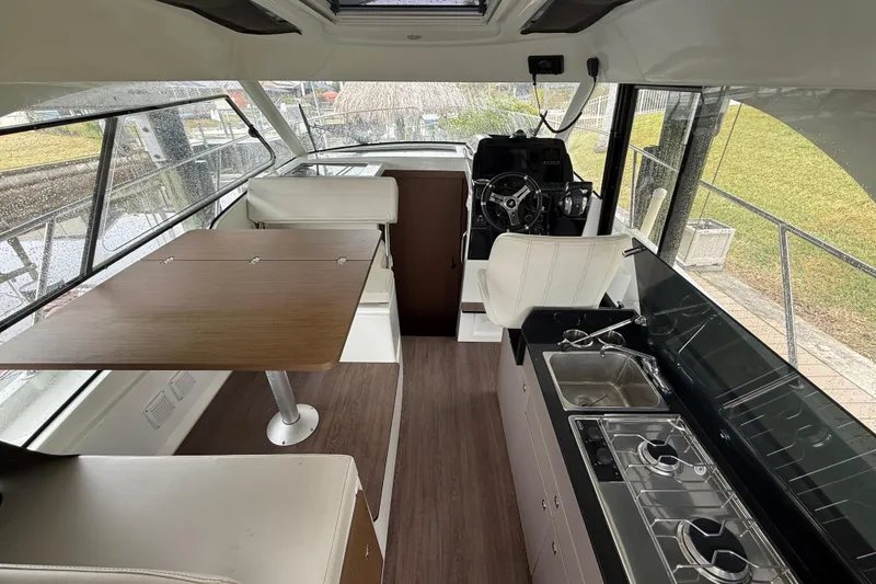 Slide: The Image of Interior of 2020 Beneteau Antares 9 boat with kitchen, seating, and helm station. - 7