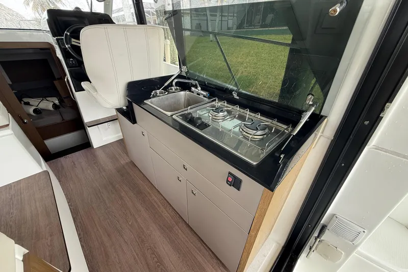 Slide: The Image of 2020 Beneteau Antares 9 interior kitchen with stove and sink, modern design. - 8